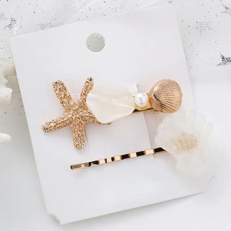 fina_hr_hrtillbehr_med_ha_0.webp Fina Hår Hårtillbehör med havets stjärna och Snäckskal vita<VSmycken Sale